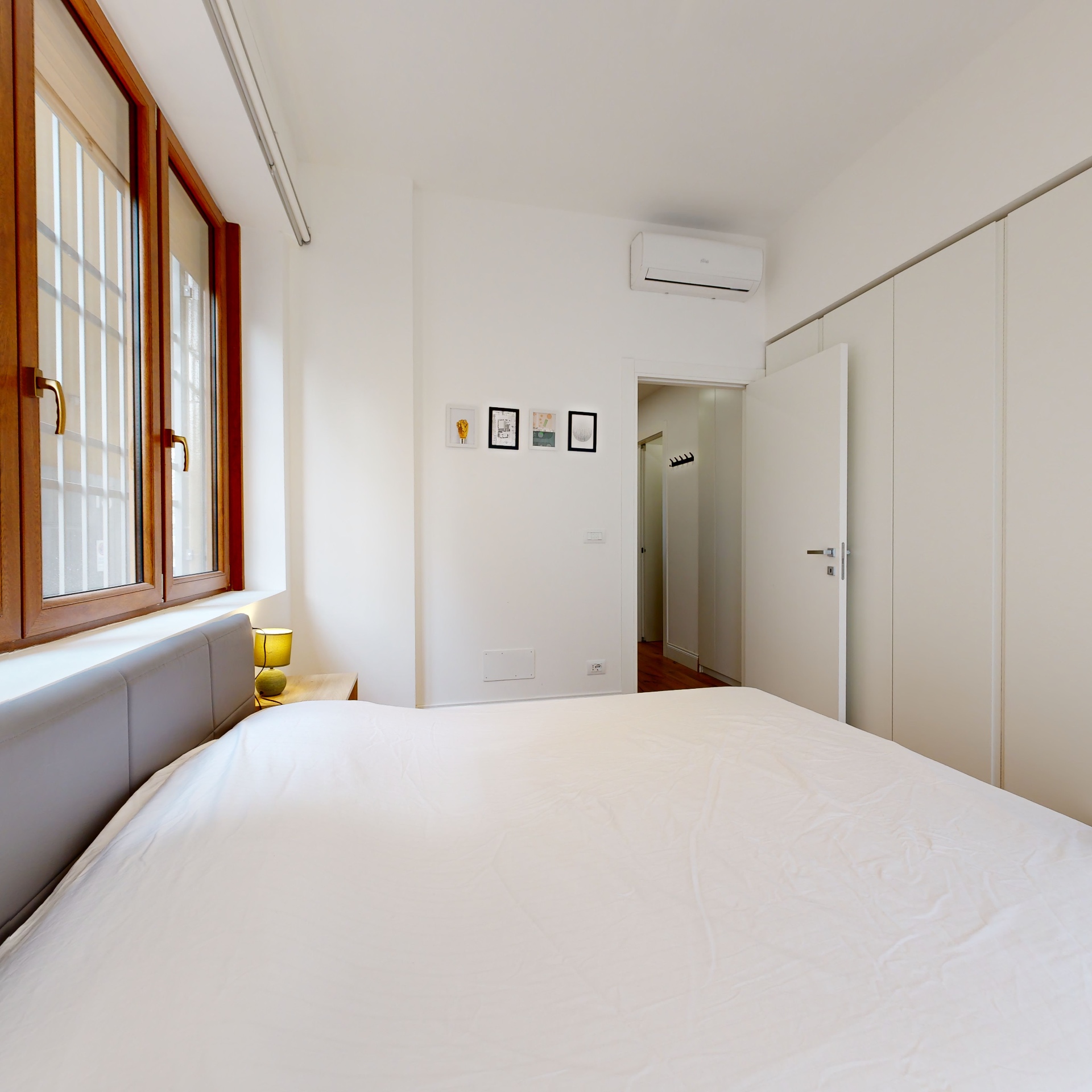 Camera da letto luminosa con finestra in legno, Casa Ricciarelli Milano Buonarroti